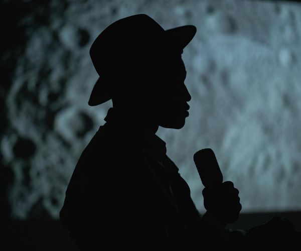 Silhouette of a person meditating against a cosmic background.